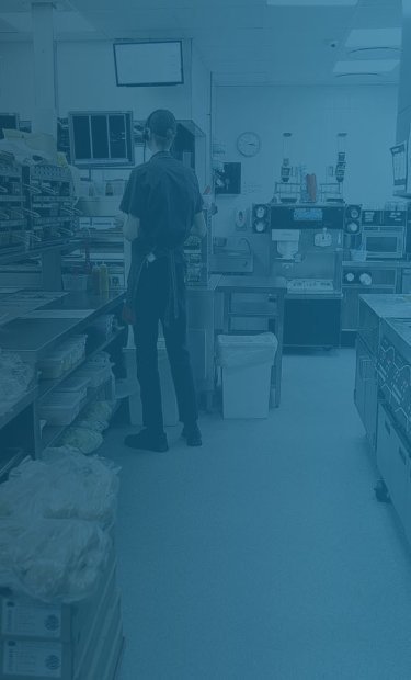 Ihmisiä keittiöympäristössä, kuvassa sininen suodatin